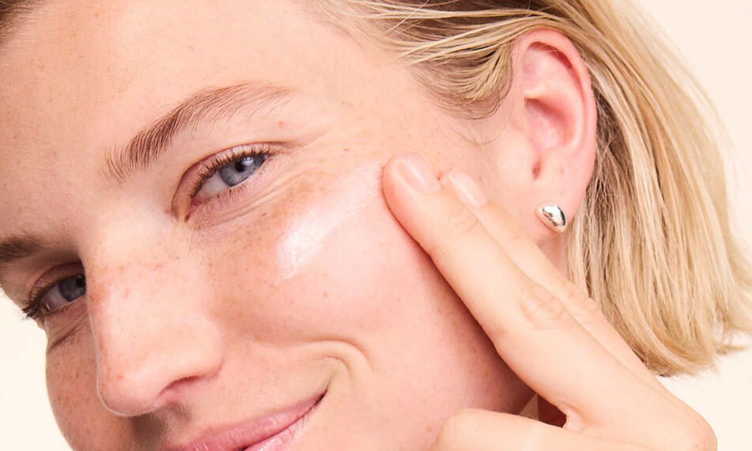 Primo piano: donna applica crema viso sulla guancia