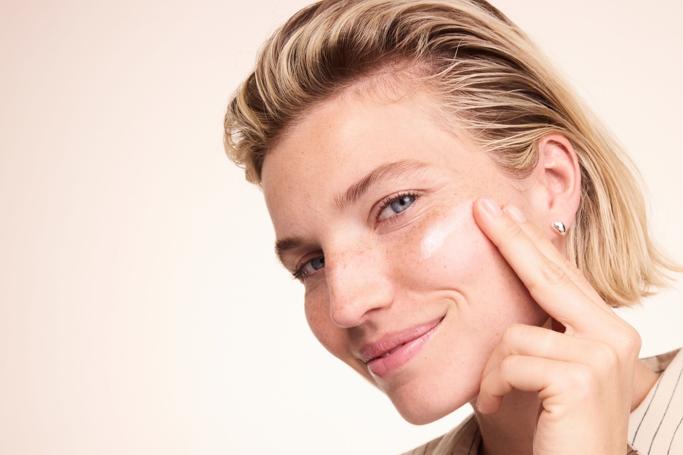 Donna applica la crema sulla guancia