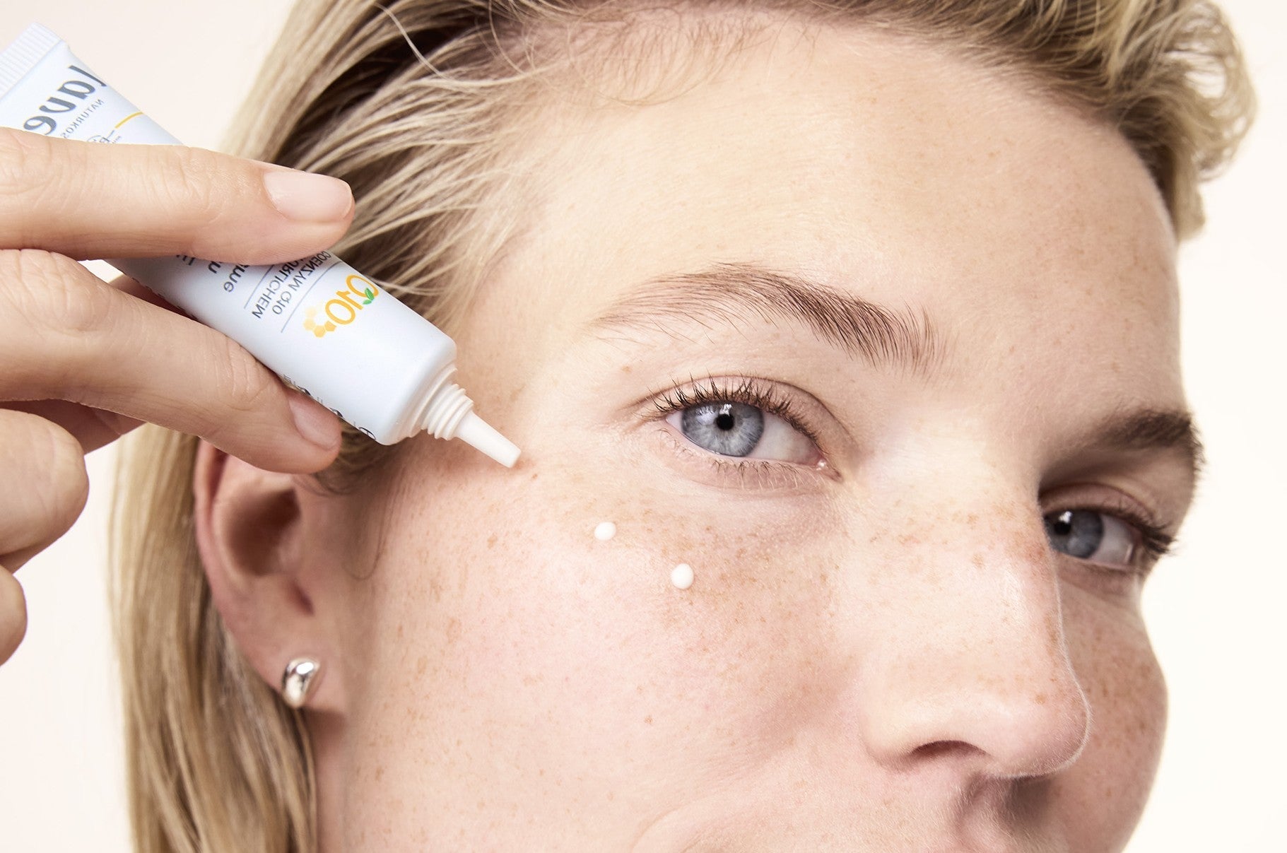 Donna applica crema contorno occhi sul viso a punti