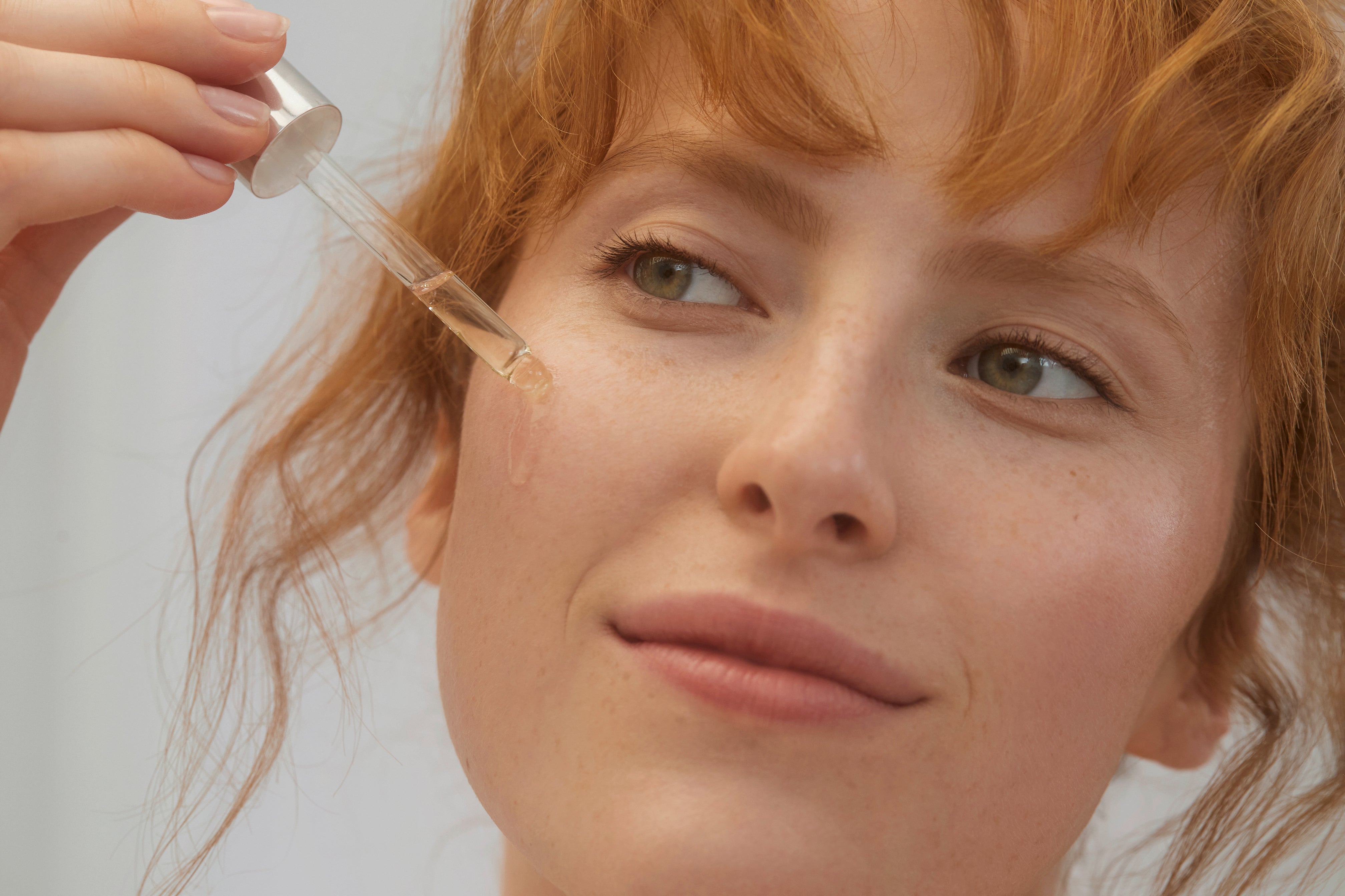 Donna applica prodotto lavera Re-Energizing sul viso con il contagocce