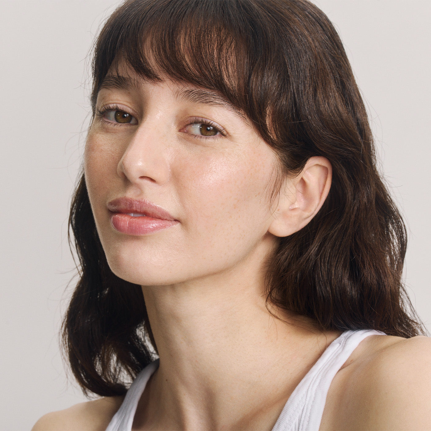 Ritratto di una giovane donna con capelli castani, frangia e occhi castani