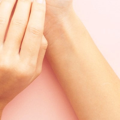 Polso e mano davanti a sfondo rosa