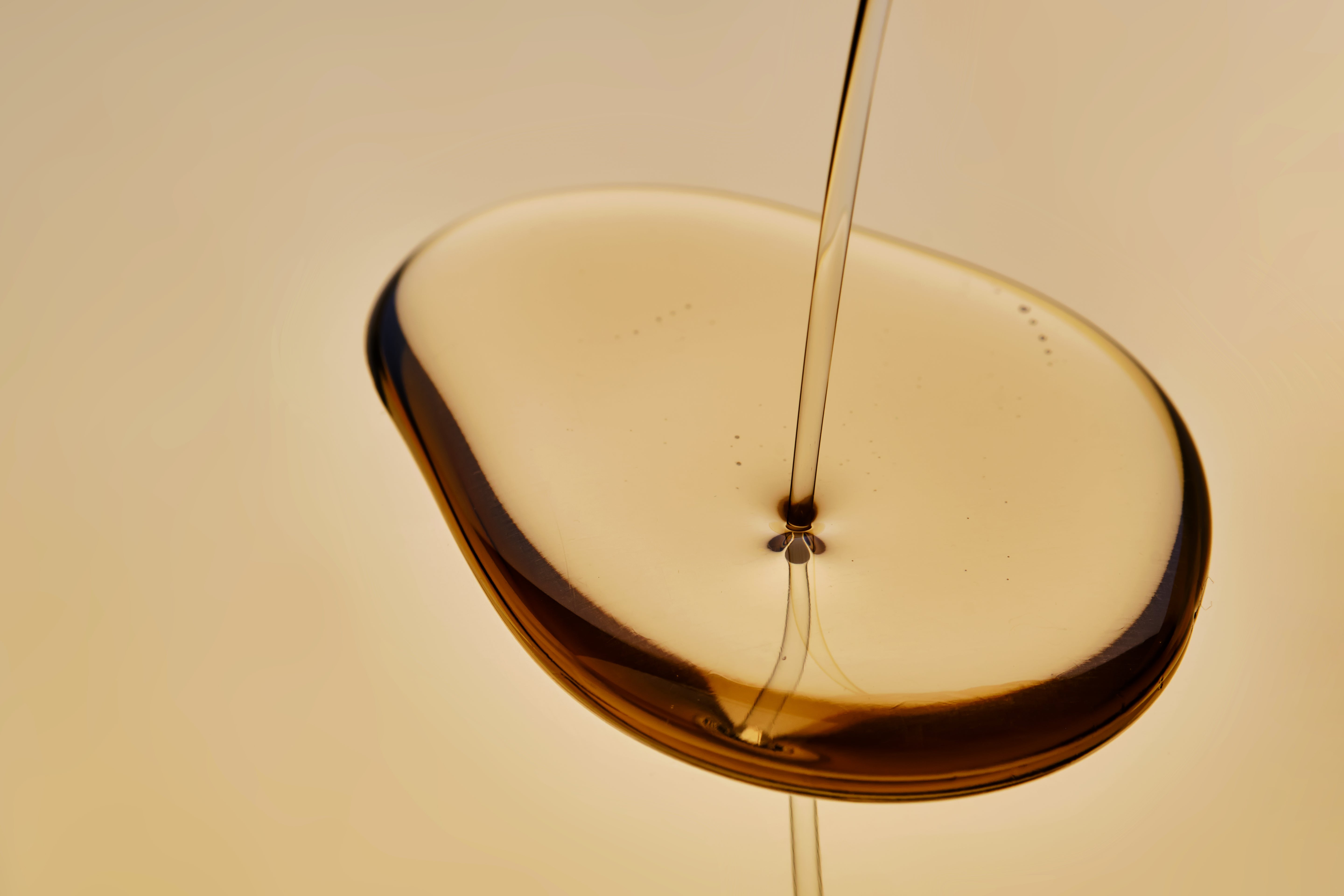 goldenes Öl fließend auf eine spiegelnde Oberfläche