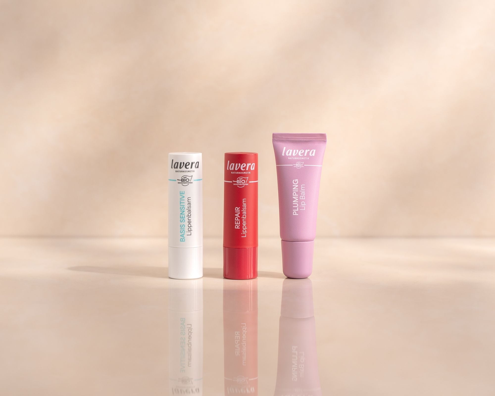 Tre prodotti per la cura delle labbra lavera affiancati su sfondo chiaro: Basis Sensitive, Repair e Plumping Lip Balm.