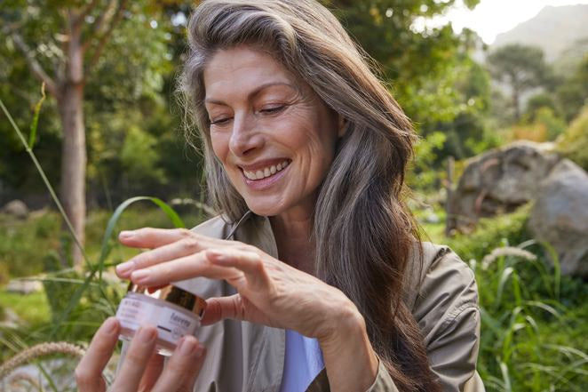 Donna matura apre vasetto crema MY AGE all'aperto