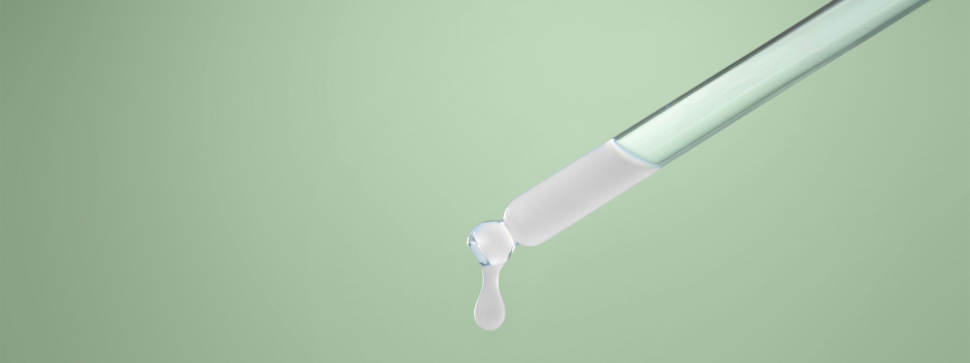 Siero da pipetta su sfondo verde