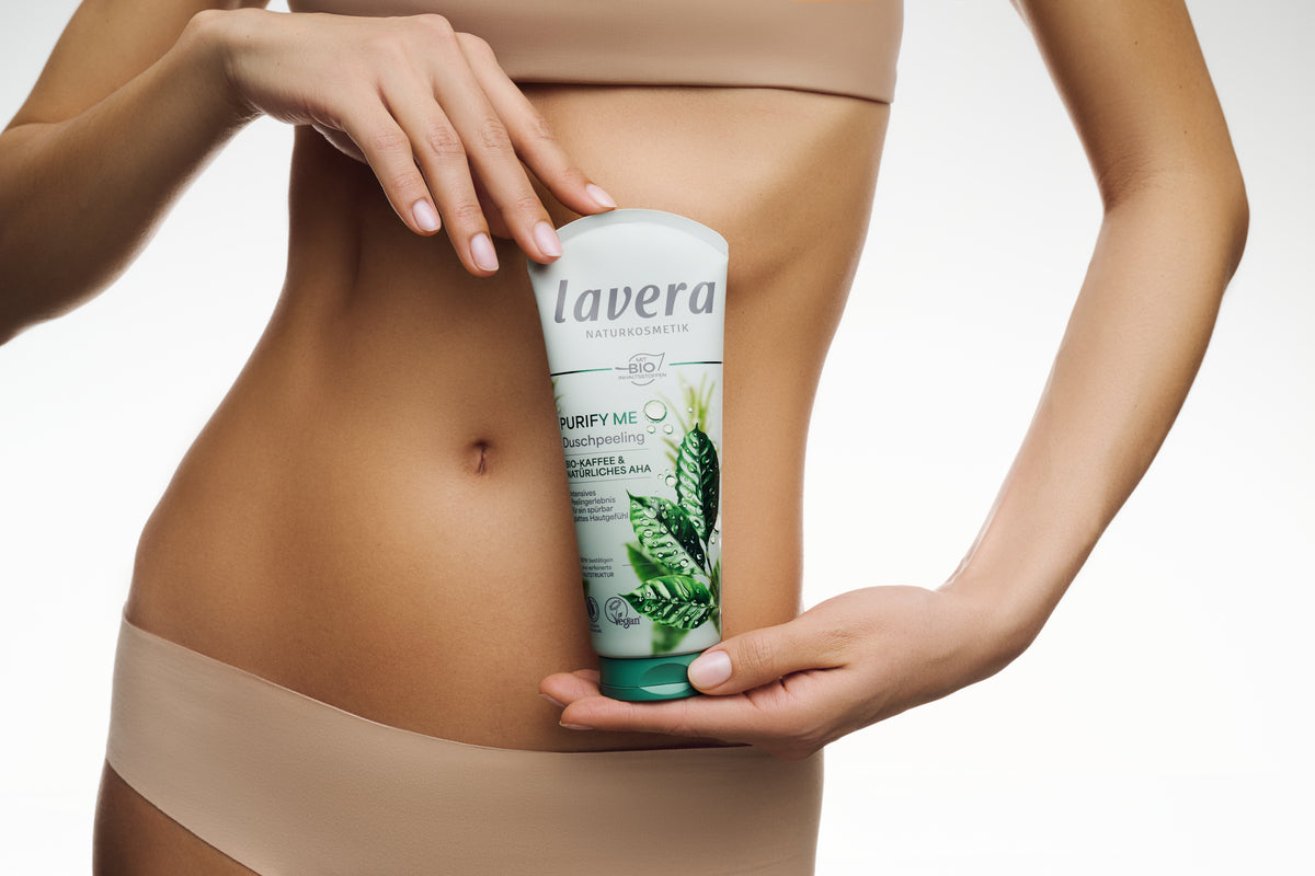 Frau hält Purify Me Duschgel vor ihren Bauch