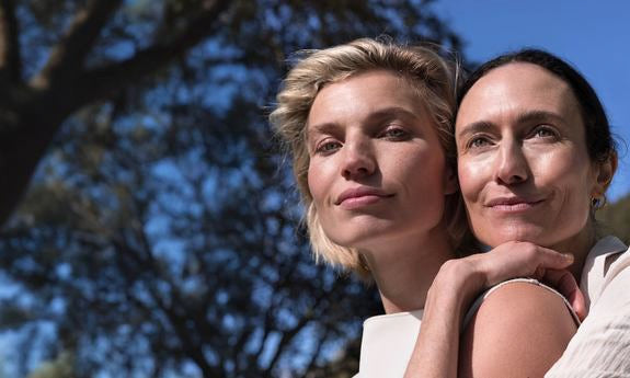 Due donne all'aperto con look naturale, strette l'una all'altra