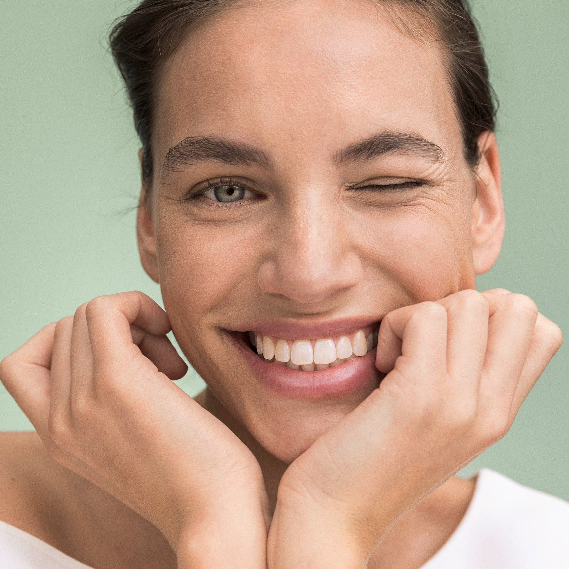 Donna tiene la testa tra le mani e sorride