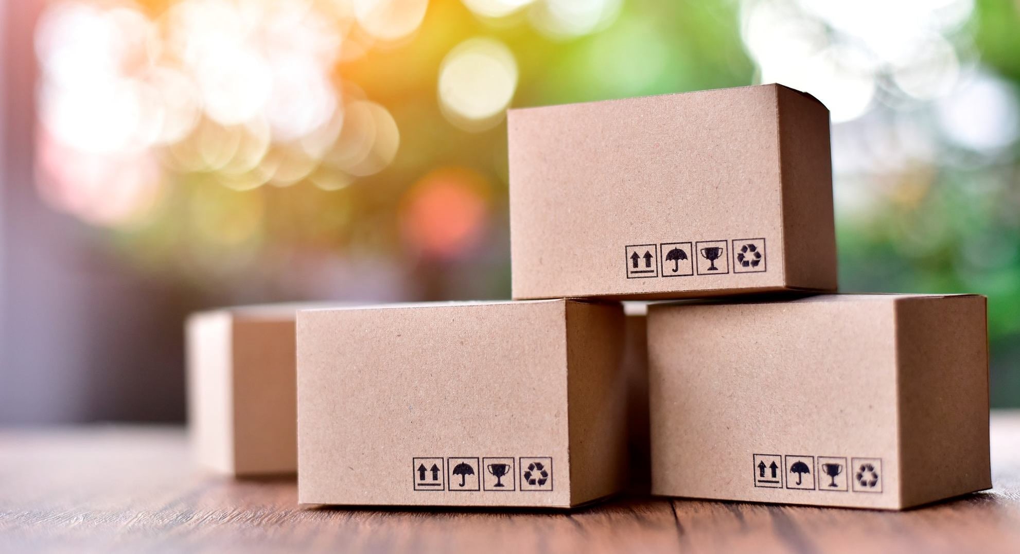 Pila di scatole con simboli di spedizione su tavolo in legno, invio pacchi